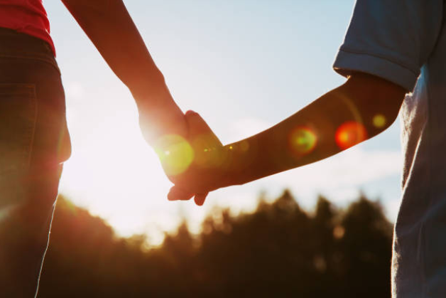 Mãos dadas ao sol, representando conexão e vínculos emocionais